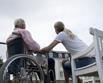 Social worker speaking to old woman in wheelchair