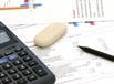 A balance sheet and calculator and rubber