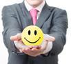 Man holds out smiley face stress ball