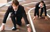 A man in a suit lining up to run a race on running track