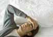 man lying on bed stressed and or tired, self diagnosis: migraine
