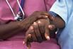 A nurse holding the hand of a child