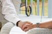 Two elderly people holding hands