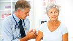 Male GP injecting arm of older woman patient