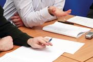 Closeup of meeting room table-  hands and notepads