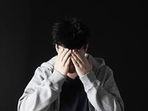 A teenage boy holding his head