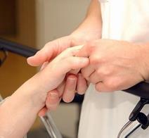 Nurse holding an elderly patient's hand