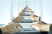 Hands using a laptop stretching into the distance
