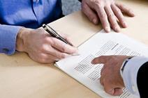 A person in a suit signing a contract