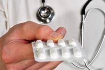 Doctor in white coat holding out tablets