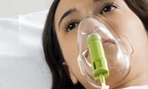 Woman lying in bed with oxygen mask