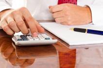 Office manager working out calculations on paper and calculator