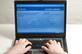 Laptop with user using Facebook