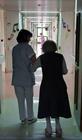 a nurse helps an older person walk