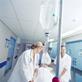 Nurses pushing trolley through hospital corridor