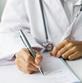 Doctor writing on a notepad at desk