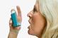 Older woman using asthma inhaler