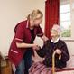 A social worker smiling at elderly patient in home