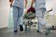 Nurses pushing hospital trolley into hospital corridor