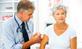 Male GP injecting arm of older woman patient