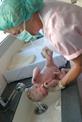 Midwife washing newborn baby
